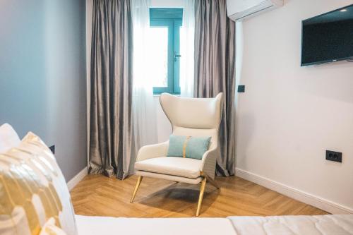 a white chair sitting in a room with a window at Apartments Eneida in Ulcinj