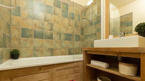 une salle de bain avec une baignoire et un lavabo et une baignoire dans l'établissement Appartements avec PISCINE INTÉRIEURE SAUNA Parking Étage 1 au Centre du Village dans Résidence Cami Réal, à Saint-Lary-Soulan