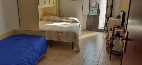 um pequeno quarto com uma cama com um cobertor azul em vecchio forno em Puntalazzo