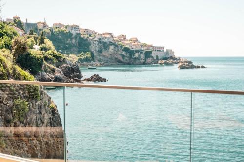 a view of a body of water with houses on a cliff at Apartments Eneida in Ulcinj