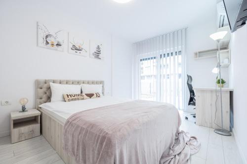Un dormitorio blanco con una cama grande y una ventana en Angel Flat, en Oradea