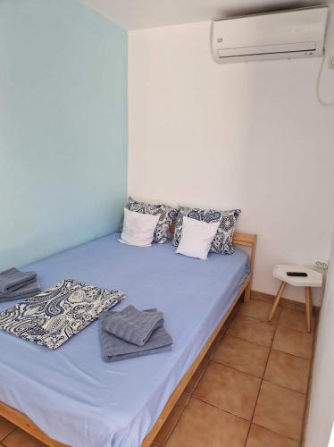 a small room with a bed with blue sheets and pillows at Pagini Din Vama in Vama Veche