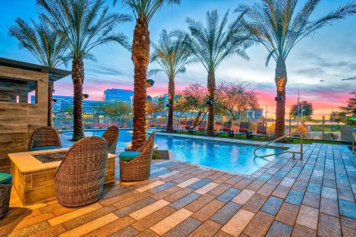 a patio with palm trees and a swimming pool at Modern 2BR CozySuites Town Lake Waterfront! in Tempe