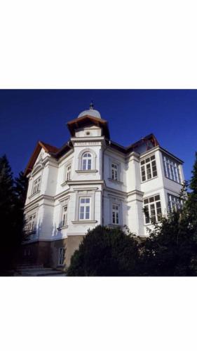 a large white building with a clock tower at Villa Reder in Bad Sauerbrunn