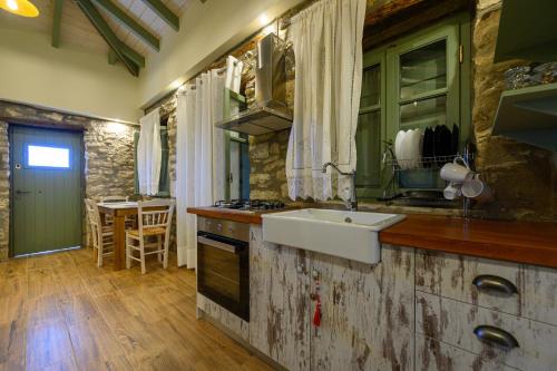 a kitchen with a sink and a stove top oven at Kalochori Luxury Cottage 