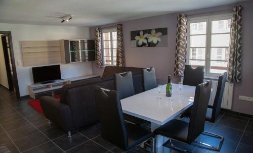a dining room with a white table and chairs at Appartements Le Hupsa Pfannala in Saint-Hippolyte