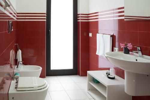 a red bathroom with a sink and a toilet at La Dimora Dei Mori in Acitrezza