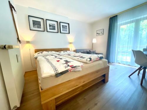 Schlafzimmer mit einem Bett, einem Schreibtisch und einem Fenster in der Unterkunft 2022 Neu renoviert- Apartments Michaela in Philippsreut