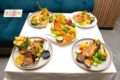 a white table with plates of food on it at Hotel Golden Flora in Beni Mellal