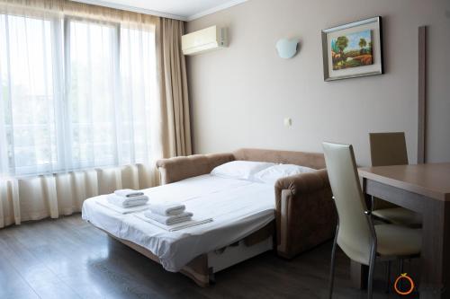 a hotel room with a bed and a table and a desk at Villa Orange in Sozopol