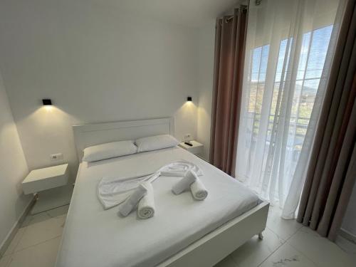 a bedroom with a white bed with towels on it at Villa Denis Ksamil in Ksamil