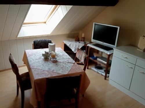 Übernachtungszimmer 2 في Schlettau: غرفة معيشة مع طاولة وتلفزيون