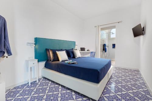 sypialnia z dużym łóżkiem z niebieskim zagłówkiem w obiekcie Casa Lou Positano w mieście Positano