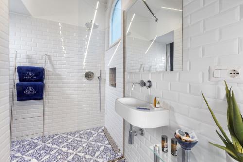 biała łazienka z umywalką i prysznicem w obiekcie Casa Lou Positano w mieście Positano