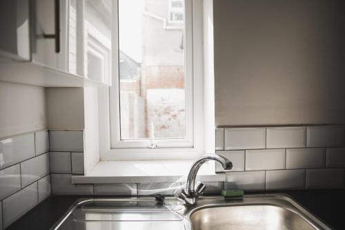 uma cozinha com um lavatório e uma janela em Green Park house em Leicester