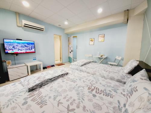 1 dormitorio con 2 camas y TV de pantalla plana en Ming House, en Yongkang