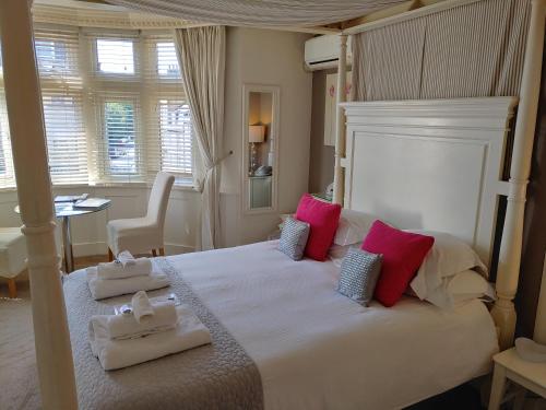 a bedroom with a large bed with towels on it at The Bath House Boutique B&B - IN-ROOM Breakfast - FREE parking in Bath