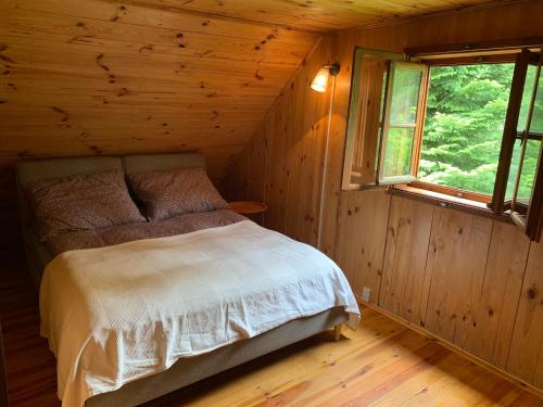 a bedroom with a bed in a log cabin at AŻ POD LAS in Zbiczno