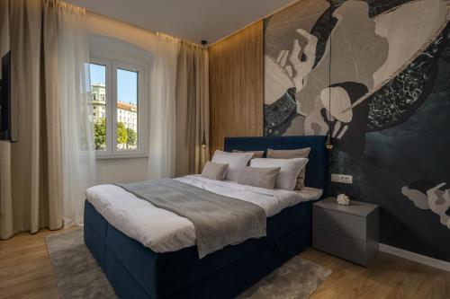 Un dormitorio con una cama azul con una pintura en la pared en Bella Vita Apartments en Rijeka