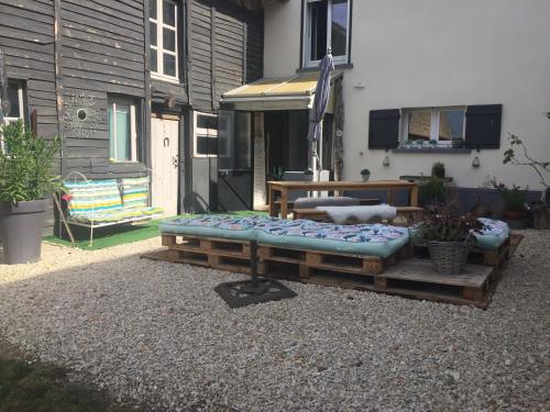 a patio with a couch and a bench in front of a house at Chaleureux in Villiers-en-Lieu