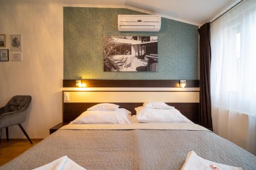 1 dormitorio con 1 cama con 2 almohadas en A16 Design Panzió, en Harkány