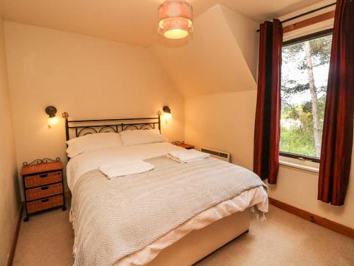 a bedroom with a large bed and a window at The Shieling in Newtonmore