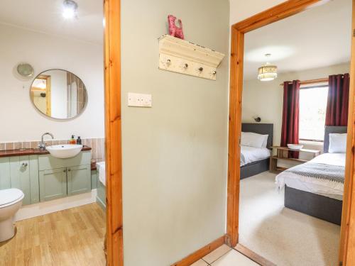 a bathroom with a sink and a toilet and a bedroom at The Shieling in Newtonmore