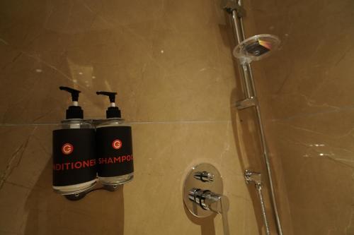 a bathroom with a shower with two bottles on the wall at Ginger Mumbai, Goregaon in Mumbai