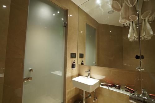 a bathroom with a sink and a shower with a mirror at Ginger Mumbai, Goregaon in Mumbai
