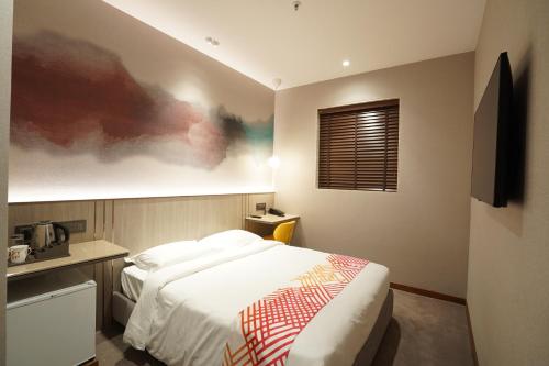 a hotel room with a bed and a window at Ginger Mumbai, Goregaon in Mumbai