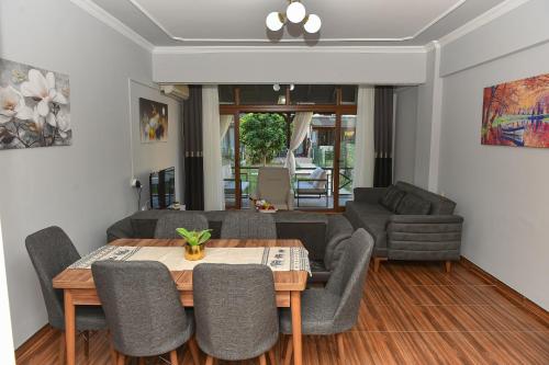 a living room with a table and chairs at VİLLA ALP'S TRİPLEX LAGOON HAVUZ OLANAĞI SUNAN in Belek