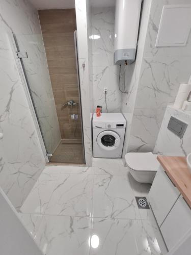 a white bathroom with a toilet and a shower at Apartmani MODUS - self service check-in in Virovitica