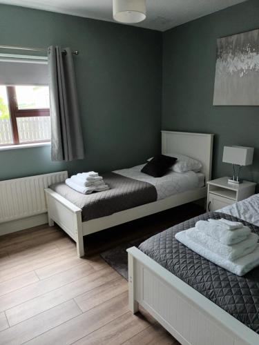 two beds in a bedroom with green walls at Parkhill House Self Catering in Ballyshannon