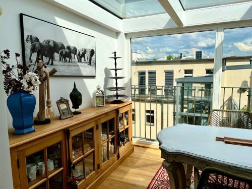 a living room with a table and a large window at Kreuzberger Szene Penthouse in Berlin