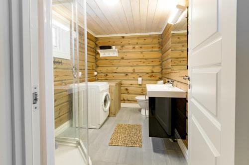 a bathroom with wooden walls and a washer and dryer at Lake View Apartment 4 bedrooms and 2 bathrooms in Sykkylven