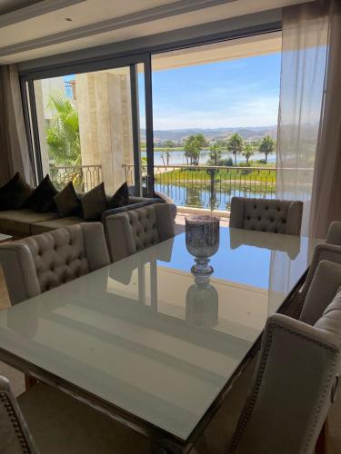 a dining room with a table and chairs and a large window at Luxueux appartement Ritz Carlton Marina Smir in Sania Torres