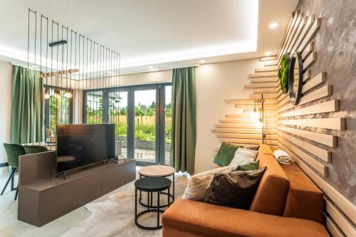 a living room with a couch and a television at SCANDIC Apartments Boží Dar in Boží Dar