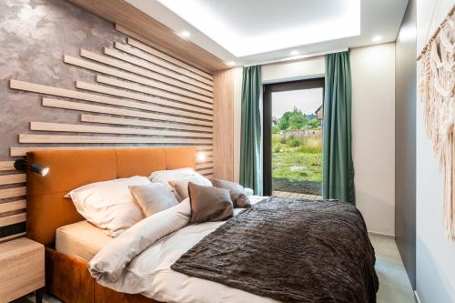 a bedroom with a bed with a wooden headboard and a window at SCANDIC Apartments Boží Dar in Boží Dar