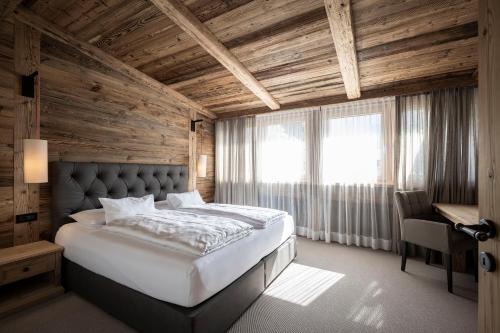a bedroom with a large bed with a wooden ceiling at Residence Cesa Sassela in Ortisei