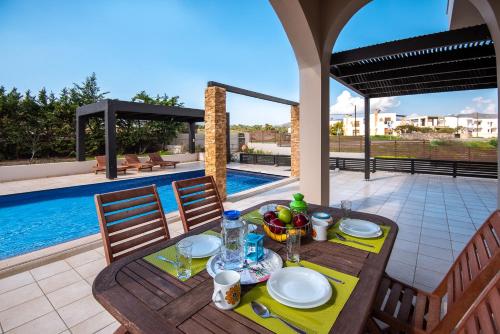 a table with plates of food on top of a patio at Blue Wave Villa - road view in Gennadi