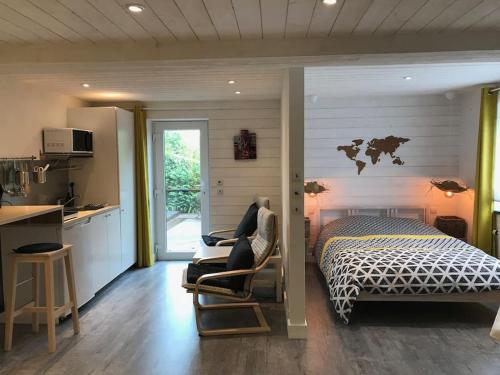 een slaapkamer met een bed, een bureau en een keuken bij Studio Au jardin fleuri in Verviers