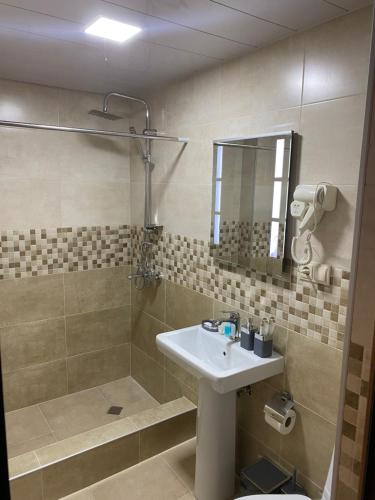La salle de bains est pourvue d'un lavabo et d'une douche. dans l'établissement Lanchvali Inn, à Mestia