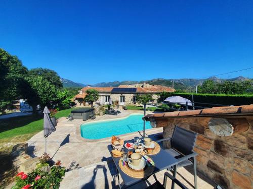 a patio with a table and chairs and a swimming pool at La babounette in Jaujac