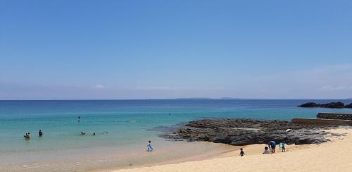 a group of people in the water at a beach at Ikijimaso in Iki