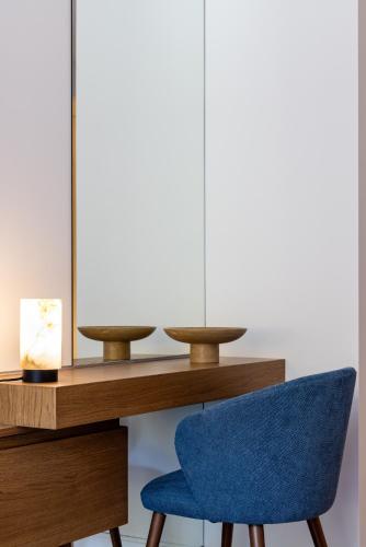 a blue chair next to a desk with a lamp at Neoma in Athens