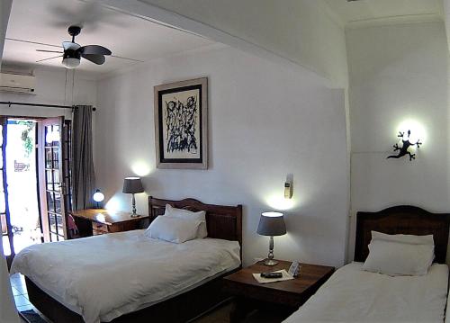 1 Schlafzimmer mit 2 Betten und 2 Tischen mit Lampen in der Unterkunft Kuru-Kuru Guesthouse in Kuruman
