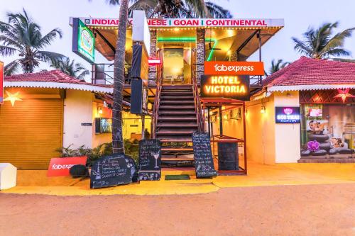 a building with signs on the front of it at FabExpress Victoria With Pool, Baga Beach in Baga