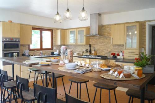 una cocina con una gran mesa de madera con comida. en La Maison des Eaux, en Saint-Jean-de-Thurac