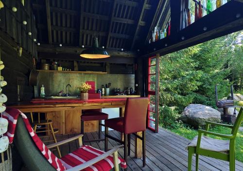 a kitchen with a counter and chairs on a deck at Puise saunahouse and outdoor kitchen at Matsalu Nature Park in Puise