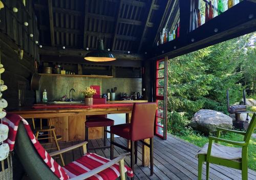 une cuisine avec un comptoir et des chaises sur une terrasse dans l'établissement Puise saunahouse and outdoor kitchen at Matsalu Nature Park, à Puise
